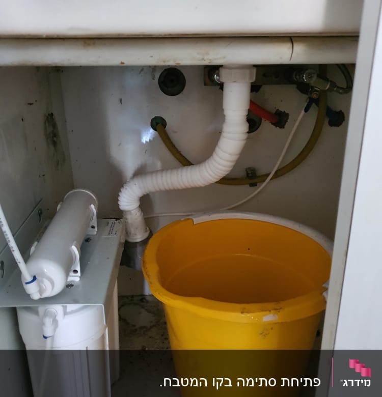דלי צהוב, צינור ניקוז, מסנן מים מתחת לכיור